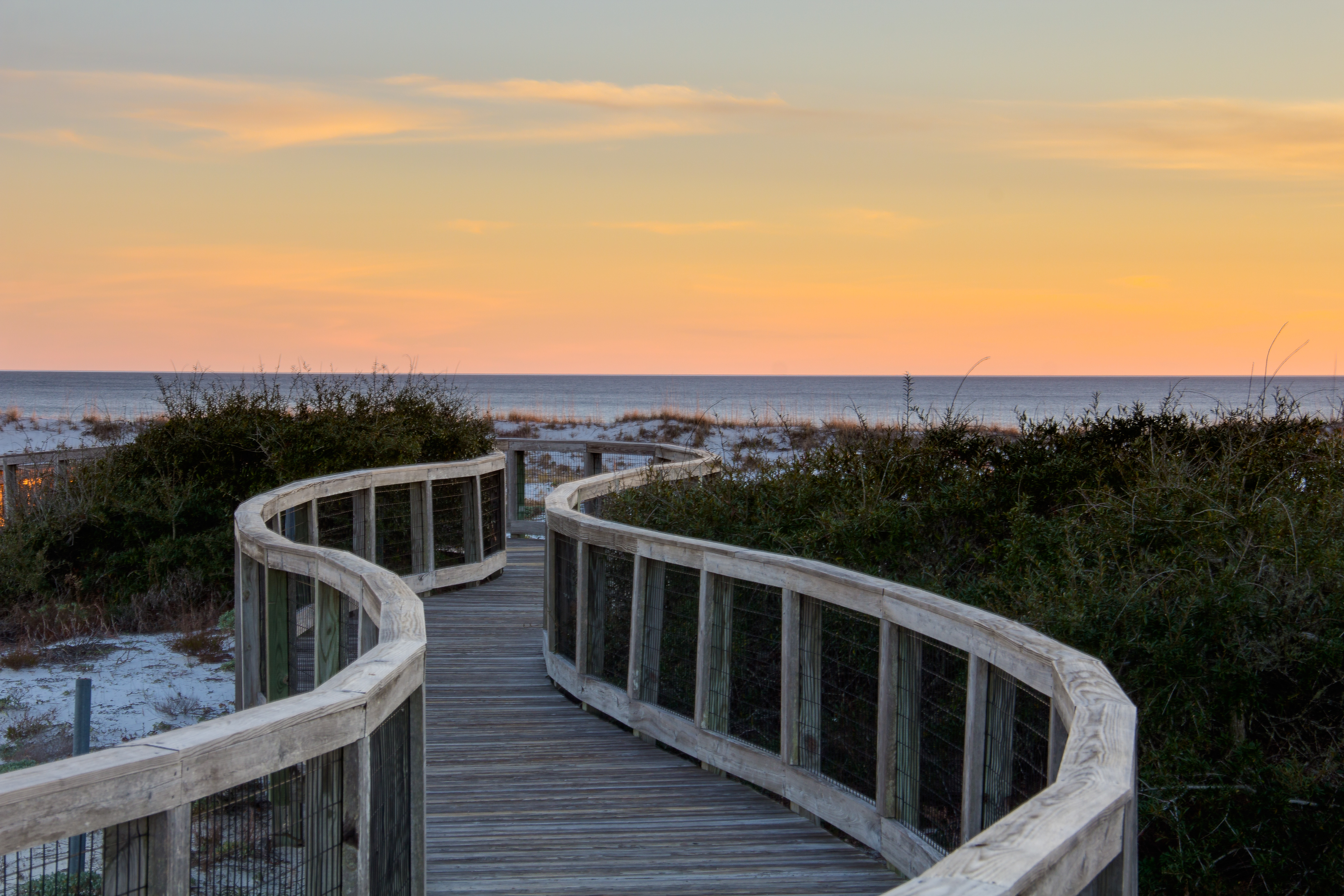 A sunset photo of the boardwalk to the beach at Watersound West Beach