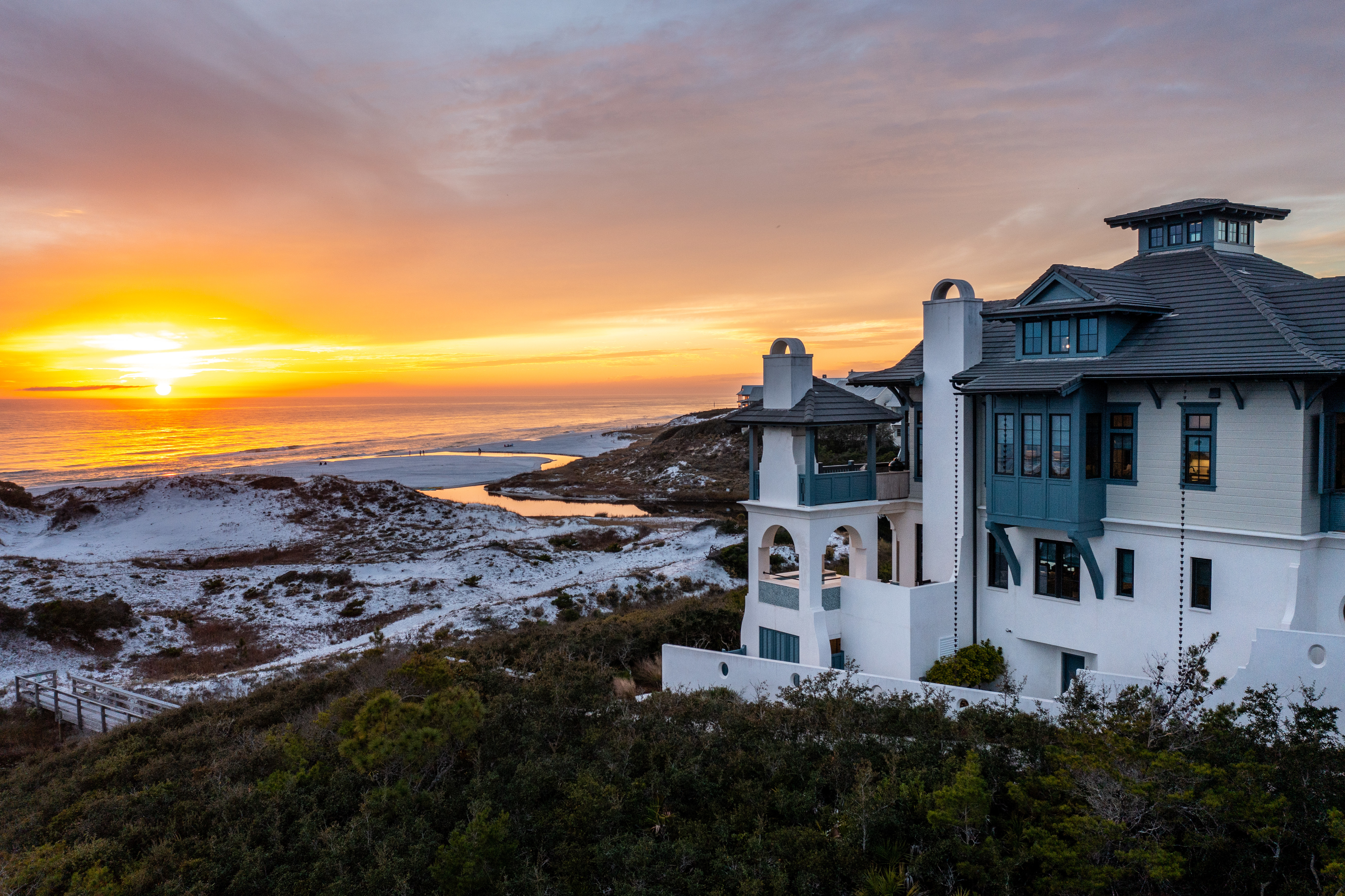 A view of a pinnacle home in The Retreat overlooking the private beach and gulf at sunset
