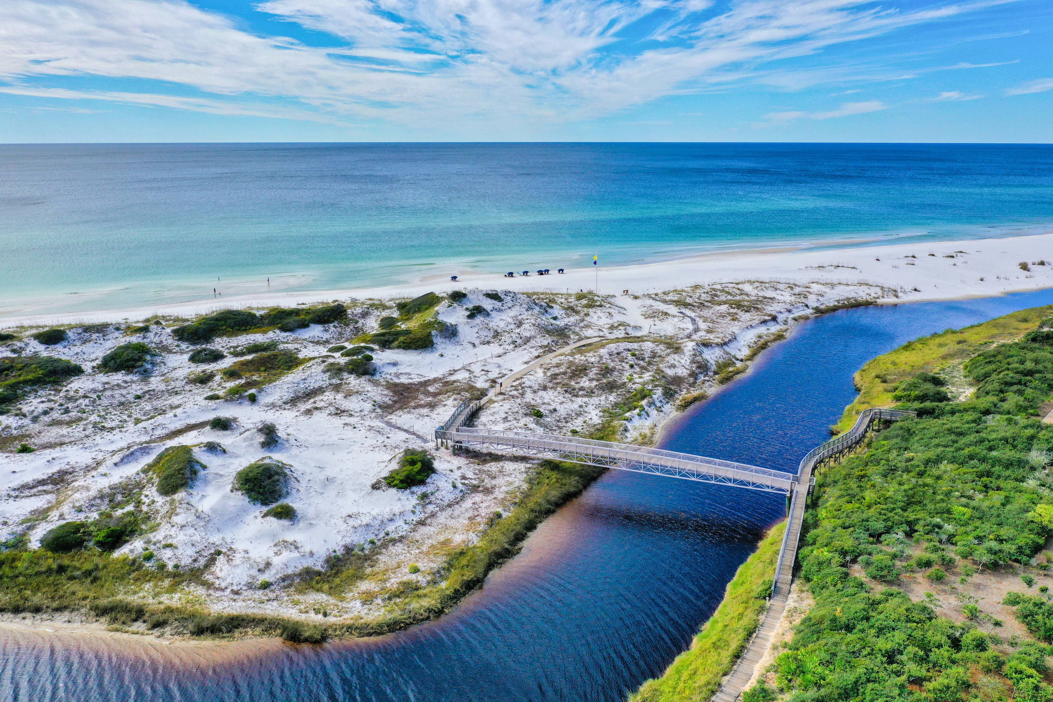 The beach and Gulf of Mexico around Watersound Beach showing a bridge to the sand dunes over a dune lake outfall