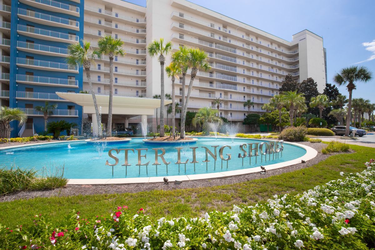 A photo of the front exterior of Sterling Shores condominium in Destin featuring the water fountain and landscaping.