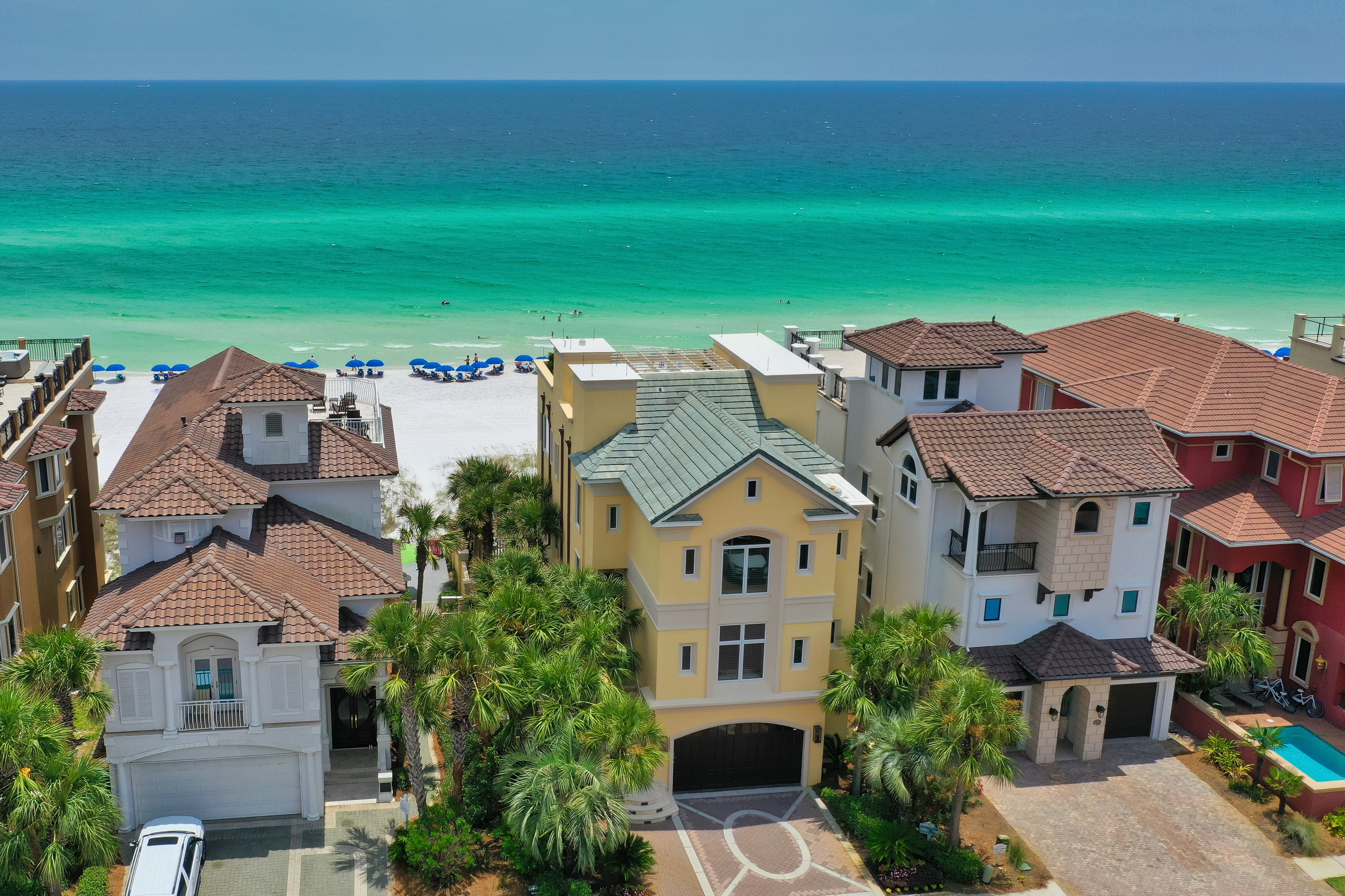 An aerial view of some Destiny By The Sea homes along the beach with emerald Gulf waters