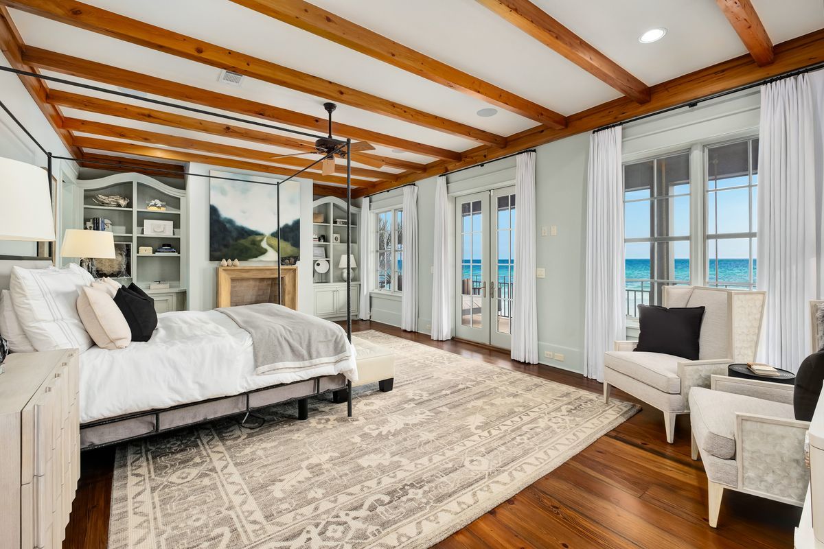 The bedroom of a luxury gulf-front home with balcony overlooking the gulf