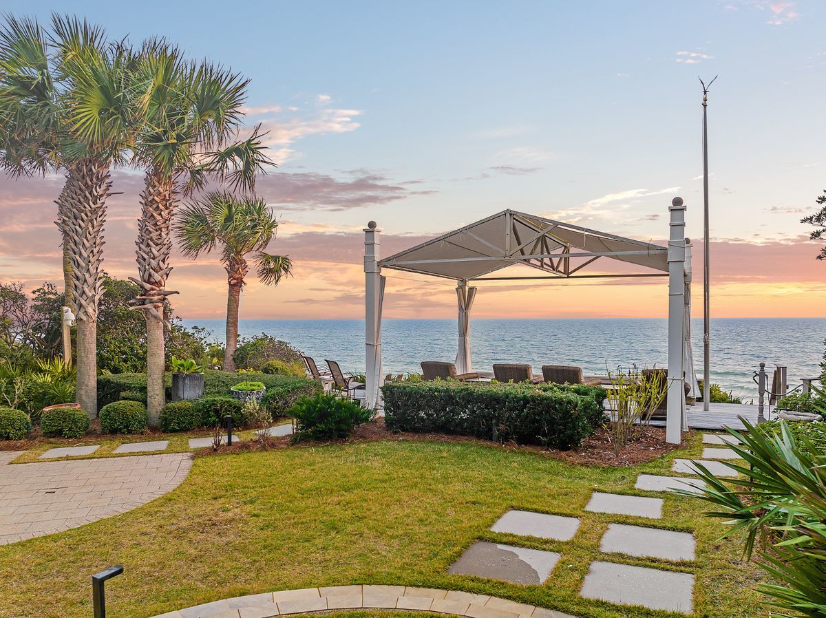 Sophisticated beach front home in Seagrove Beach with lawned backyard and pavilion with panoramic views of the Gulf of Mexico, perfect for laid back relaxation at home.